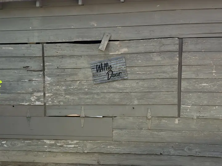 Small tin sign marking the Willie Door at Gruene Hall